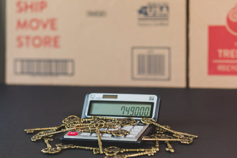 A close-up view of a calculator displaying the number 749,800 on its screen, surrounded by a pile of gold-colored keys of various shapes and sizes with intricate teeth and bows, scattered across a bla