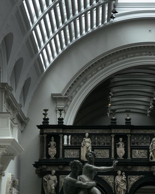 Photograph of the exterior of the Victorian-era building housing the Victoria and Albert Museum, with its intricate stone façade, arched entrance, and tall central tower topped with decorative elemen